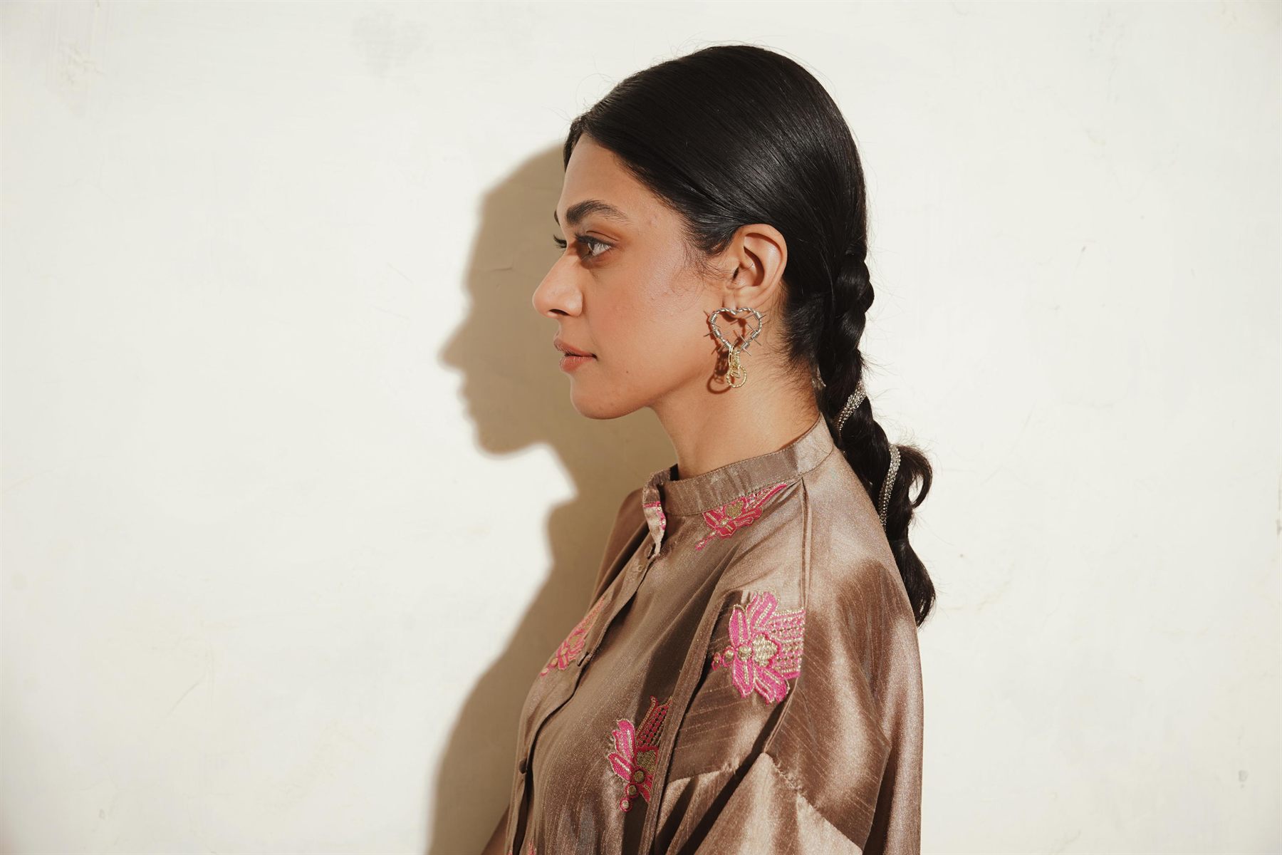 Profile portrait with statement earrings and a braided ponytail